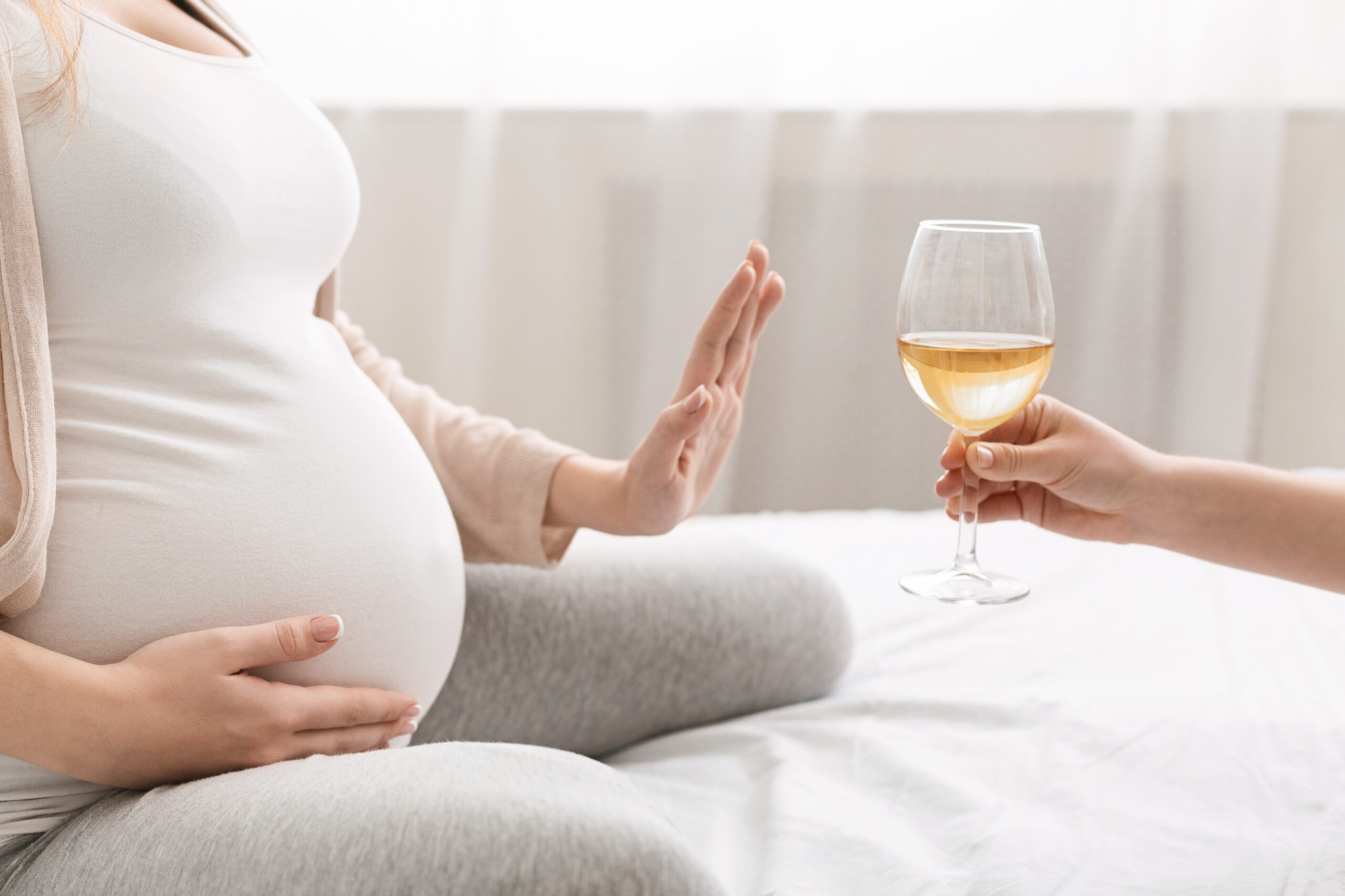 Junge schwangere Frau weigert sich, Wein zu trinken